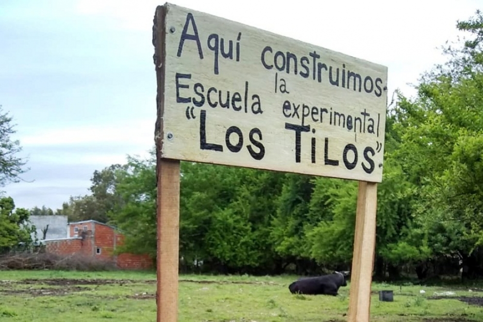 Padres y profesores colocaron un cartel anunciando la construcci&oacute;n de la escuela en el predio.