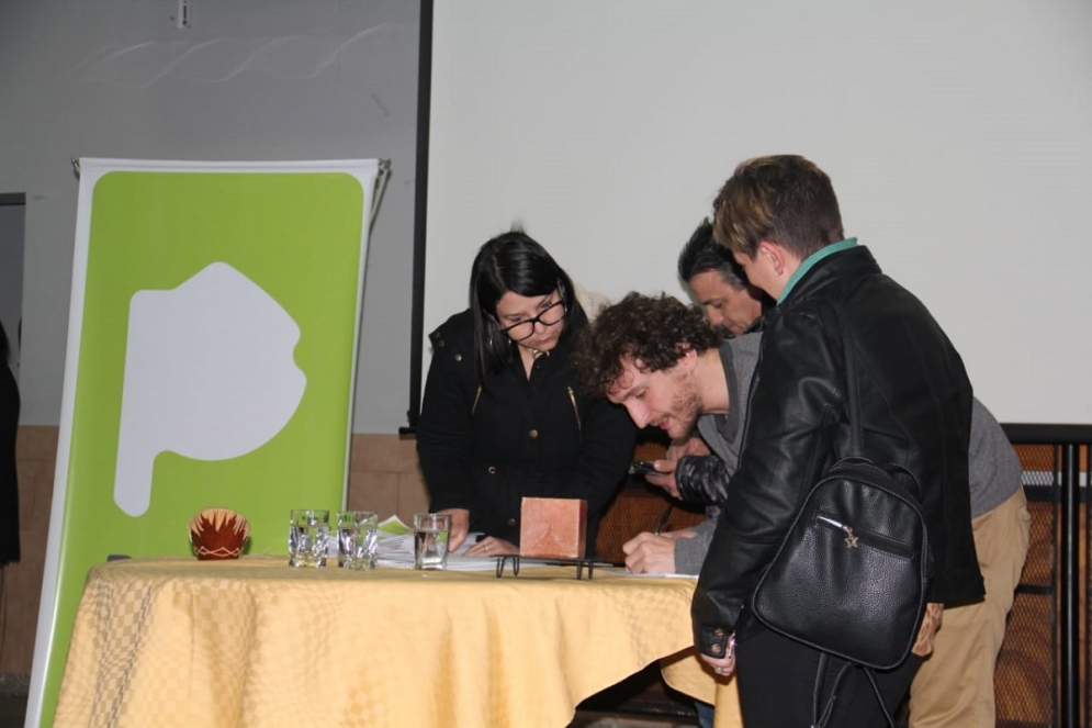 Funcionarios del ministerio entregando una de las 26 escrituras. 