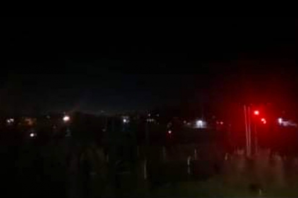 La luz roja del sem&aacute;foro emerge en medio de la oscuridad.