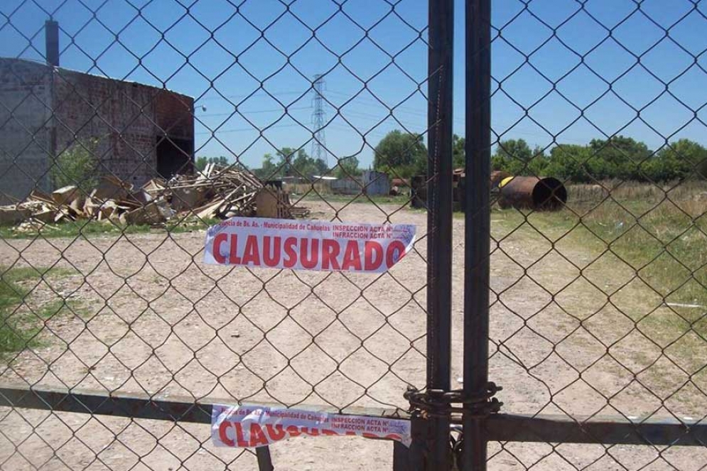 Las fajas de clausura puestas en el port&oacute;n de ingreso al predio. 