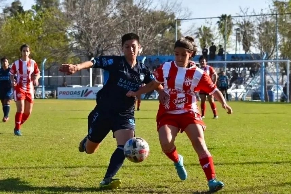 Martina Iraola disputando la bola contra la defensora de la "crema".