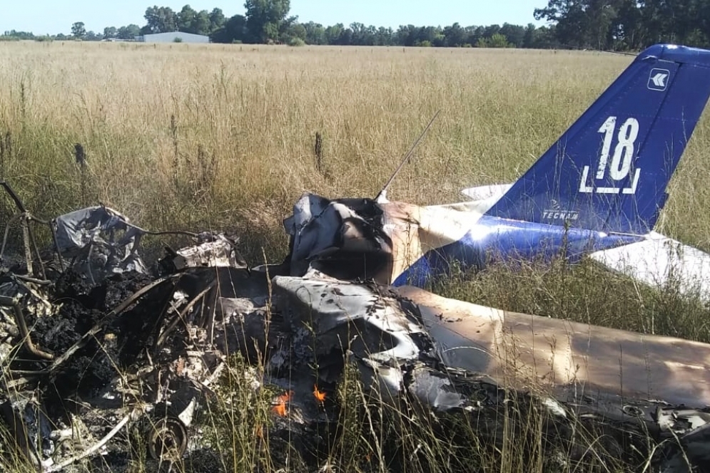 La avioneta Tecman estrellada, a&uacute;n con llamas.